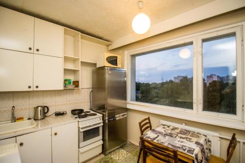 a small kitchen with a table and a window at Song Festival apartment, 5-10 min from bus/airport in Tallinn