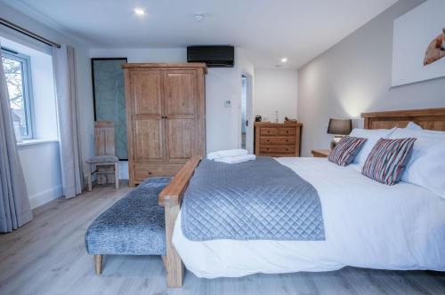 a bedroom with a large bed and a dresser at Suite 7 - Sleeping Giant Hotel - Pen Y Cae Inn in Brecon