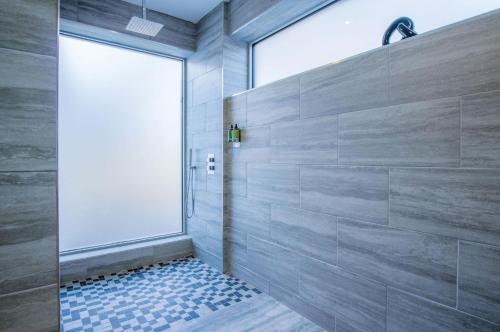 ein Bad mit einer Dusche und einer Glastür in der Unterkunft Suite 15 - Sleeping Giant Hotel - Pen Y Cae Inn in Brecon