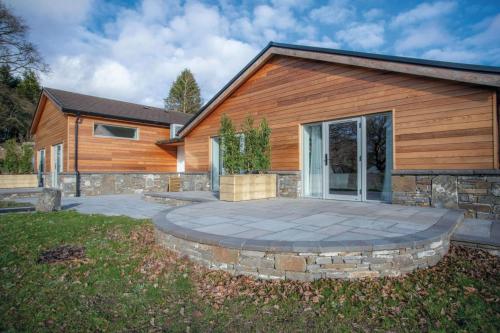 a house with a patio in front of a building at Suite 9 - Sleeping Giant Hotel - Pen Y Cae Inn in Brecon