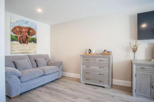 a living room with a blue couch and a dresser at Suite 10 - Sleeping Giant Hotel - Pen Y Cae Inn in Brecon