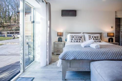 a bedroom with a bed and a sliding glass door at Suite 10 - Sleeping Giant Hotel - Pen Y Cae Inn in Brecon