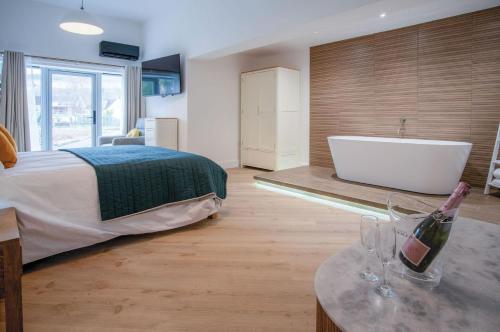 a bedroom with a bed and a tub and a sink at Suite 5 - Sleeping Giant Hotel - Pen Y Cae Inn in Brecon