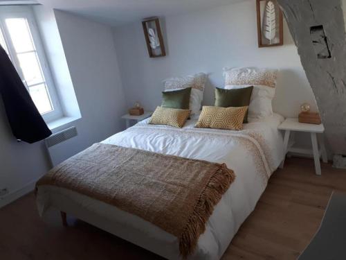 - une chambre avec un lit blanc et des oreillers dans l'établissement ALEIDA, à La Rochelle