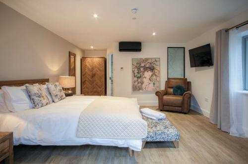 a bedroom with a large white bed and a chair at Suite 1 - Sleeping Giant Hotel - Pen Y Cae Inn in Brecon