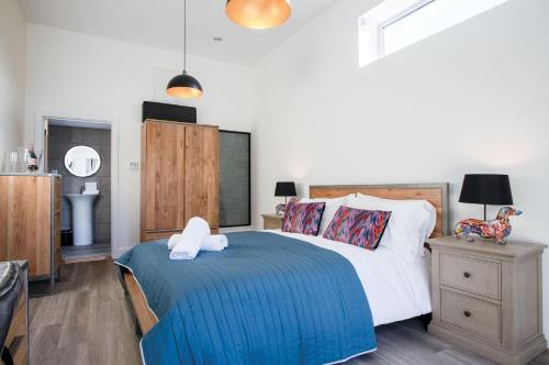 a bedroom with a bed with a blue blanket at Suite 11 - Sleeping Giant Hotel - Pen Y Cae Inn in Brecon