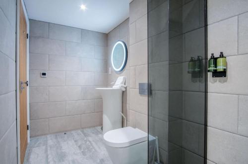 uma casa de banho com um WC e uma cabina de duche em vidro. em Suite 11 - Sleeping Giant Hotel - Pen Y Cae Inn em Brecon