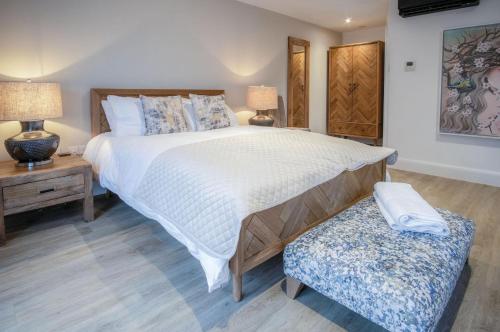 a bedroom with a large white bed and a bench at Suite 1 - Sleeping Giant Hotel - Pen Y Cae Inn in Brecon