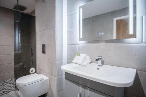 a white bathroom with a sink and a toilet at Suite 3 - Sleeping Giant Hotel - Pen Y Cae Inn in Brecon