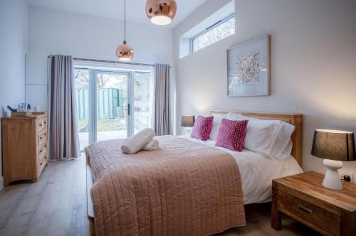 a bedroom with a large bed with pink pillows at Suite 12 - Sleeping Giant Hotel - Pen Y Cae Inn in Brecon