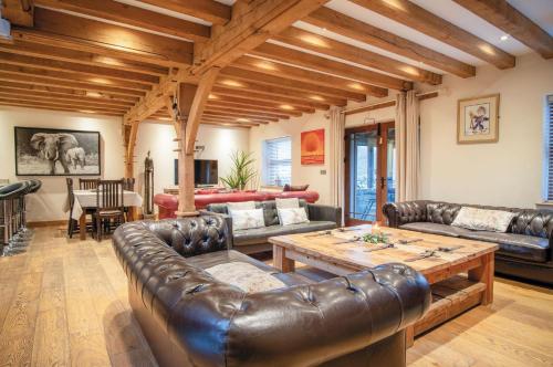 uma sala de estar com mobiliário de couro e uma mesa em Oak Lodge - The Sleeping Giant - Pen Y Cae Inn em Brecon
