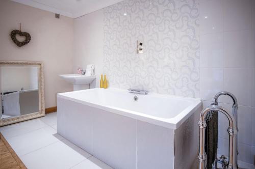 a white bathroom with a sink and a mirror at Oak Lodge - The Sleeping Giant - Pen Y Cae Inn in Brecon