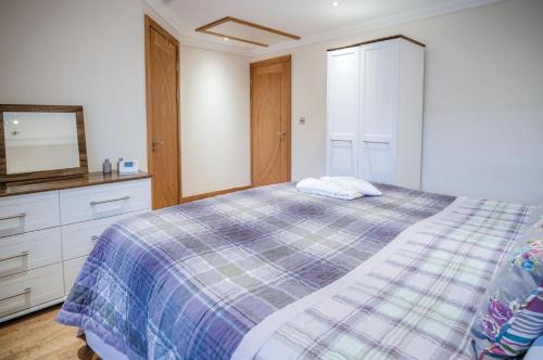 a bedroom with a bed and a dresser and a mirror at Oak Lodge - The Sleeping Giant - Pen Y Cae Inn in Brecon