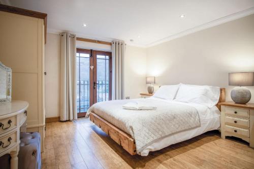 a white bedroom with a bed and a window at Oak Lodge - The Sleeping Giant - Pen Y Cae Inn in Brecon