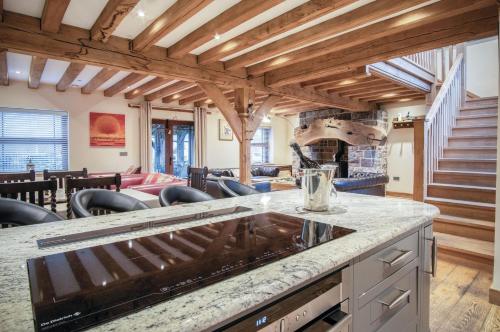 a kitchen with a counter and a living room at Oak Lodge - The Sleeping Giant - Pen Y Cae Inn in Brecon