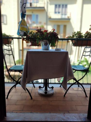 a table with a plant on a balcony with two chairs at La Casa di Mà in Piancastagnaio