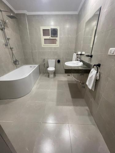La salle de bains est pourvue d'une baignoire, de toilettes et d'un lavabo. dans l'établissement New Lotus Hotel, au Caire