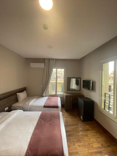 una camera d'albergo con due letti e una finestra di New Lotus Hotel a Il Cairo