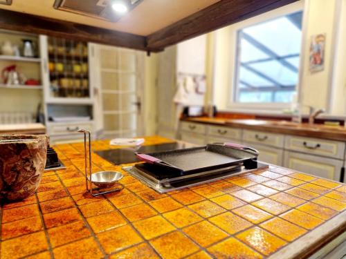 a kitchen with a counter top with a stove top at Les Tamaris 4 étoiles in Omonville-la-Rogue
