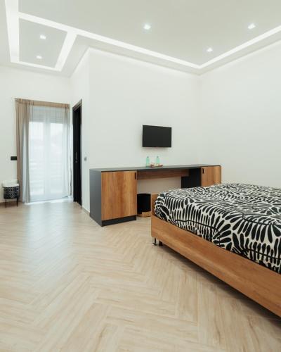 a bedroom with a bed and a flat screen tv at B&B Mirò Luxury aeroporto capodichino Napoli in Naples