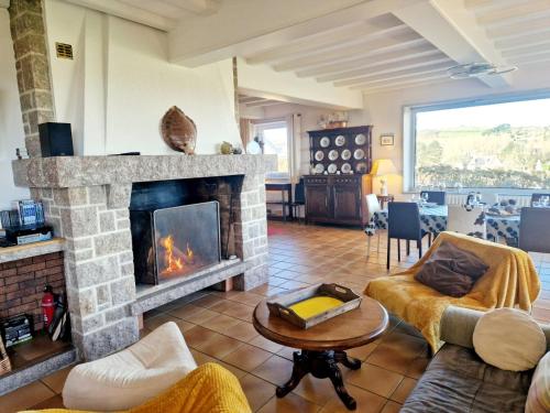 a living room with a fireplace and a table at Les Tamaris **** YourHostHelper in Omonville-la-Rogue