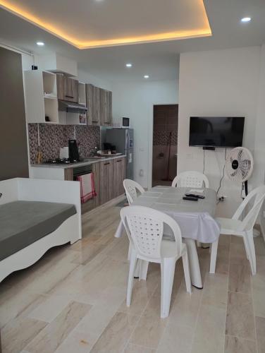 a living room with a table and chairs and a kitchen at Appartement Les Cyclamens Hammam-lif Tunisie Afrique in Hammam-Lif
