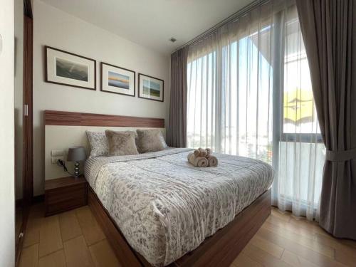 a bedroom with a bed with a teddy bear on it at Luxury and modern condo in Central Chiang Mai - Astra Condo in Chiang Mai