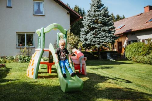 a young boy is playing on a slide in a yard at Lichkovská chalupa in Lichkov