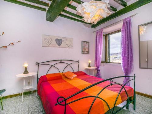 モンテカティーニ・ヴァル・ディ・チェーチナにあるCasa Zia Secondaの紫色のカーテンが備わるベッドルーム1室です。