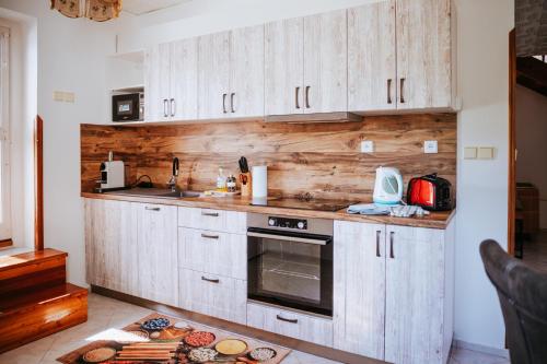 a kitchen with wooden cabinets and a counter with food at Lichkovská chalupa in Lichkov