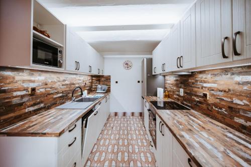 a kitchen with white cabinets and a brick wall at Lichkovská chalupa in Lichkov
