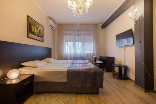 ソチにあるApartamenty na Moskovskoyのベッドルーム1室(大型ベッド1台、シャンデリア付)