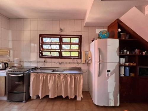 uma cozinha com um frigorífico branco e um lavatório em Alma leve! em Florianópolis