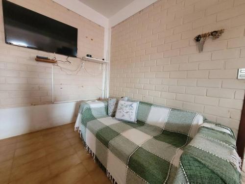 um quarto com um sofá e uma televisão na parede em Alma leve! em Florianópolis