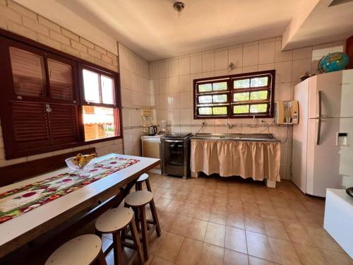 uma cozinha com um frigorífico e uma mesa com bancos em Alma leve! em Florianópolis