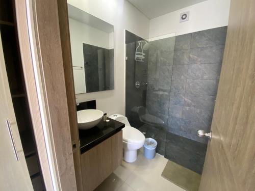 y baño con aseo, lavabo y ducha. en Apartamento piso 26 en Cartagena de Indias