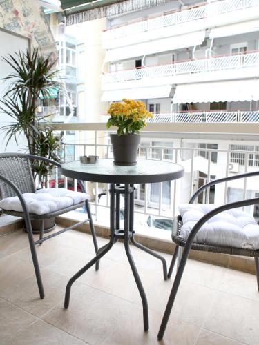 a table with a potted plant on a balcony at Psimithefto Luxury Apartments in Thessaloniki