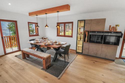 CergnatにあるCharmant et spacieux chalet moderneのテーブルとキッチンのあるダイニングルーム