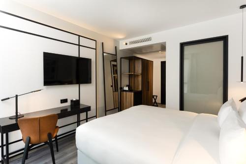 a bedroom with a bed and a desk and a television at Radisson Hotel Tunis, City Center in Tunis