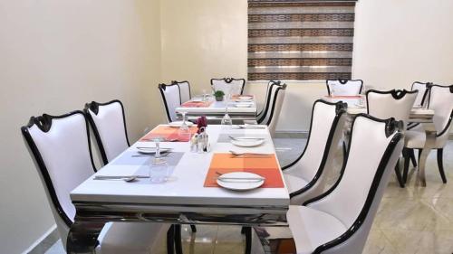 a dining room with a table and chairs with plates and dishes at Alim Royal Hotel and Suites in Abuja