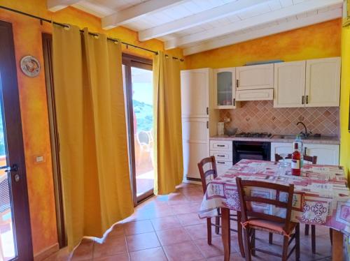 una cucina con tavolo e sedie e una sala da pranzo di House with sea view Sardinia a Solanas