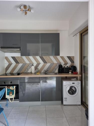 une cuisine avec un lave-linge et un lave-linge dans l'établissement Le Carla studio 2 personne, à Nice