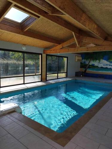 - une grande piscine dans un bâtiment doté de fenêtres dans l'établissement La jolie Villa du Pesquier, à Saint-Crépin-et-Carlucet
