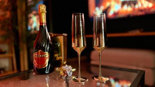 - deux verres à champagne assis sur une table dans l'établissement Nuit de rêve : spa, sauna, cinéma, à Villemomble