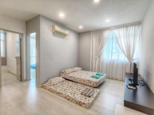 a living room with two beds and a television at Harmony suites 1, 3-5 pax, Jelutong Georgetown Penang in Jelutong