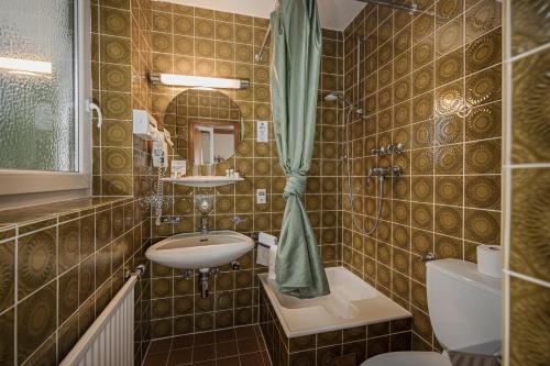 uma casa de banho com um lavatório e um WC em Hotel Alpina - Thermenhotels Gastein em Bad Hofgastein