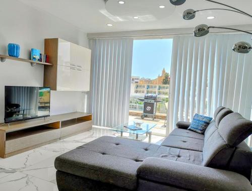 a living room with a couch and a tv at 'Home away from Home' by the sea in St Julian's