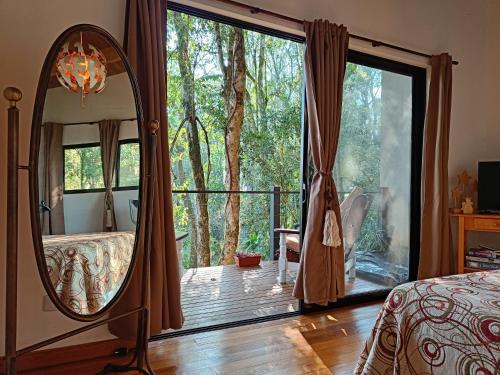 sypialnia z lustrem i łóżkiem oraz balkonem w obiekcie Vista al Rio Arami 