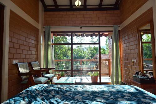 a bedroom with a bed and a large window at Sereno Barn Eco Stay Chikmagalur in Chikmagalūr