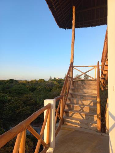 a staircase to a house with a view of the ocean at Watamu Beach Cottages in Watamu